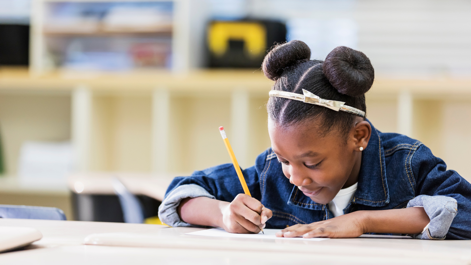 school aged girl writing in a note book