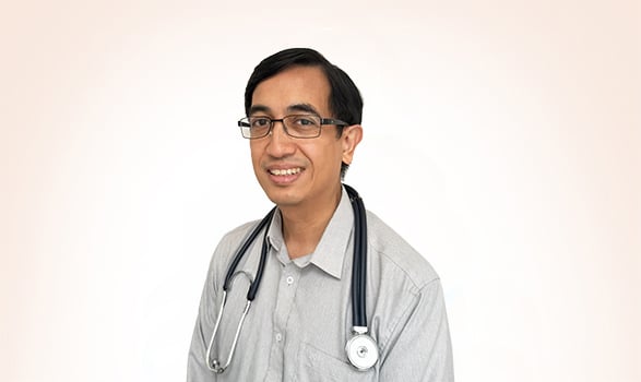 A male doctor wearing glasses and a stethoscope around his neck.